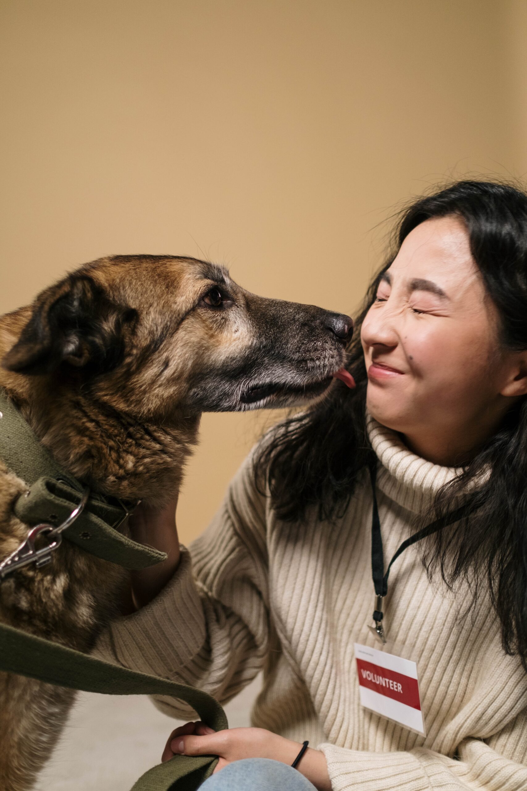 woman smiling and dog about to lick her face